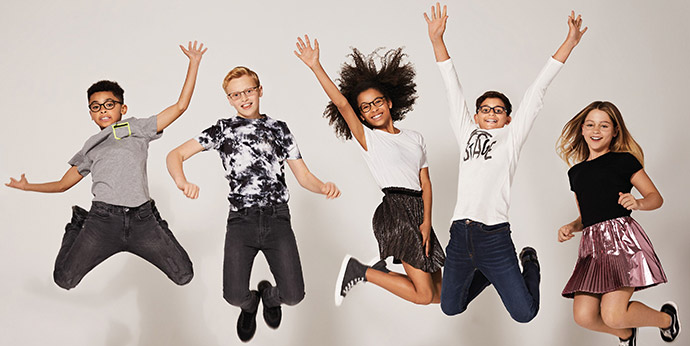 a group of kids jumping wearing glasses